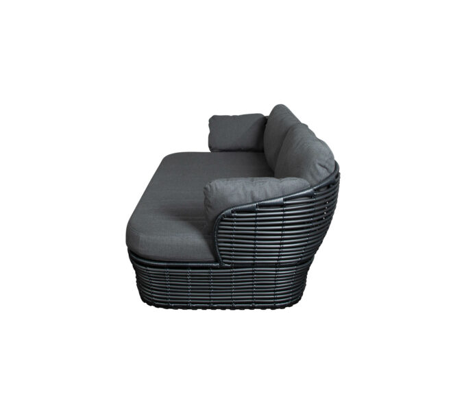 Von Cane-line die Basket Lounge graphit mit grauen QuickDry-Kissen in der Seitenansicht.