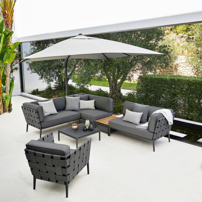 Conic Lounge in grau mit Sessel, Tisch-Box und Couchtisch, alles von Cane-line.