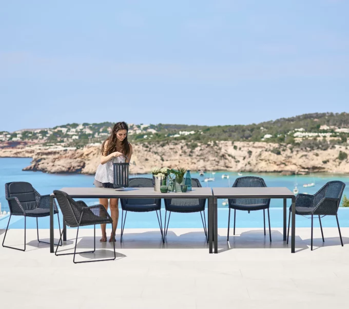 Lavagraue Pure-Tisch von Cane-line mit schwarzen Breeze-Sesseln.