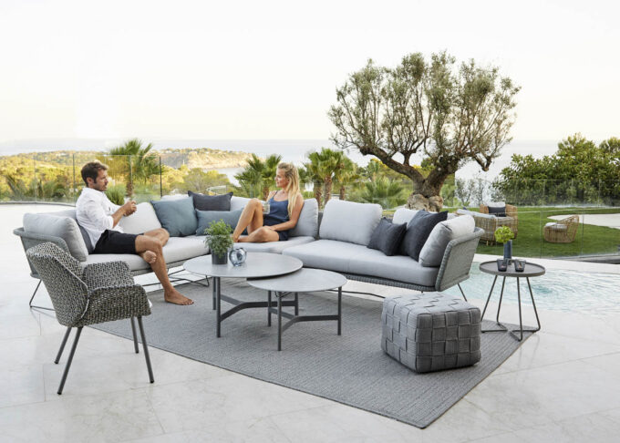 Horizon-Loungein hellgrau im Zusammenspiel mit dem Vibe Lounge-Sessel, Twist- und on the move Tischen, Cube-Hocker und einem Circle-Teppich, alles von Cane-line.