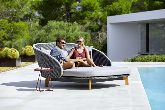 Das Peacock Daybed von Cane-line mit wetterfesten QuickDry Kissen mit grauem Airtouch-Bezug.