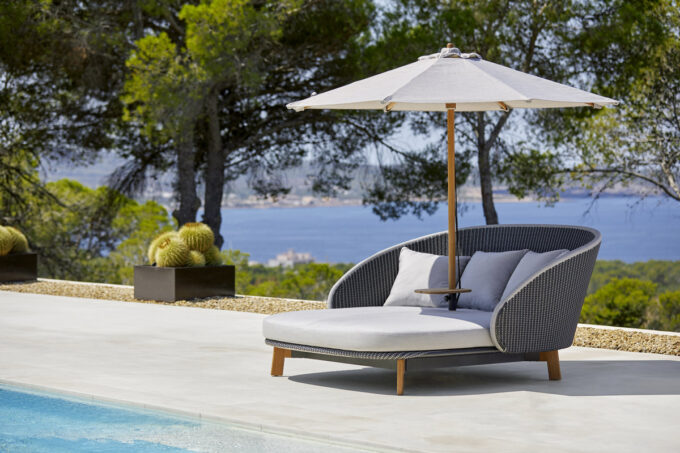 Peacock Daybed von Cane-line kombiniert mit dem Classic Sonnenschirm niedrig.