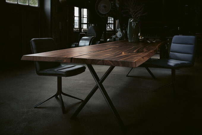 18Hundert Baumtisch mit schwarzem Kreuzfuss. Unikats-Tischplatte in massivem, rustikalem Nussbaum.